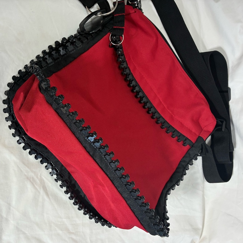 Very unique red nylon bag with huge working zipper accents